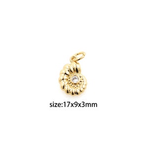 May include: Gold-toned seashell charm with a clear rhinestone in the center. The charm is 1.7 cm wide, 0.9 cm tall, and 0.3 cm thick.  size:17x9x3mm