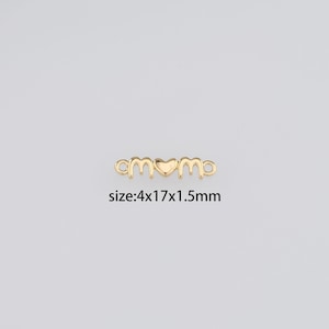 Può includere: Ciondolo in metallo dorato con la parola "mom" e un cuore al centro. Il ciondolo misura 4 per 17 per 1,5 millimetri.