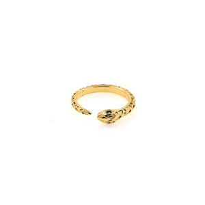 May include: A gold snake ring with a green stone eye. The ring is open and has a textured snake design.