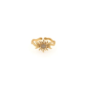 May include: A gold adjustable ring with a sun design featuring clear cubic zirconia stones.