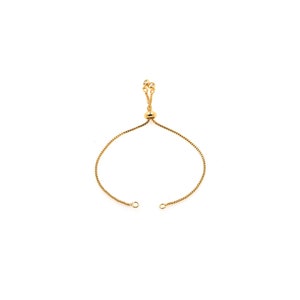 May include: A gold adjustable bracelet with a small round bead and clear crystal accents.