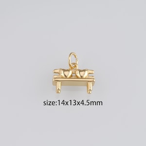 May include: Gold-tone charm featuring two hearts sitting on a bench. The charm measures 1.4 x 1.3 x 0.45 inches.