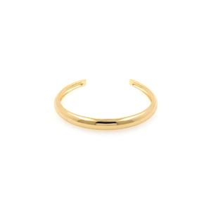 Op de afbeelding: Een gouden armband met een glad, afgerond oppervlak.