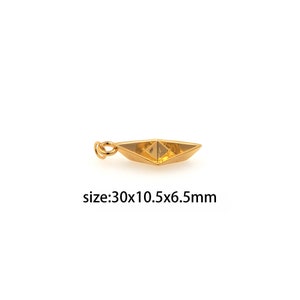 May include: Gold-coloured paper boat charm with a loop for attaching to a necklace or bracelet. Size: 30x10.5x6.5mm.