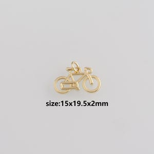 May include: A gold-colored bicycle charm with a loop for hanging. The charm is approximately 0.6 x 0.8 x 0.1 inches in size, as indicated by the text on the image. The bicycle has a classic design.
