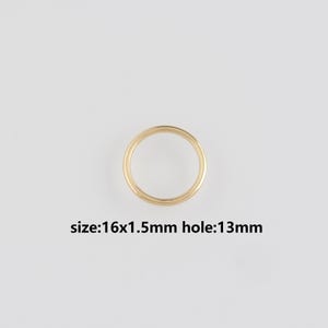 May include: A gold-colored ring with a circular design. The ring's dimensions are 16x1.5mm, with a 13mm hole. The ring is set against a plain white background. The text "size: 16x1.5mm hole: 13mm" is visible.