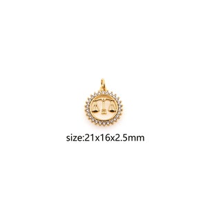May include: Gold-tone pendant charm featuring a Libra zodiac symbol with clear cubic zirconia stones around the edge. The pendant measures 21 x 16 x 2.5 mm.