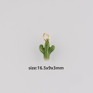 May include: A gold-coloured cactus charm with green detailing. The charm measures 1.65cm long, 0.9cm wide, and 0.3cm thick. It features a loop at the top for attachment. The text "size:16.5x9x3mm" is below the charm.