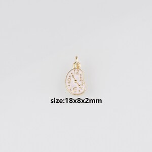 Puede incluir: Un dije dorado con una esfera de reloj blanca y números negros. El dije tiene un diseño único y derretido, con el texto "size:18x8x2mm" debajo. Mide 1,8 cm x 0,8 cm x 0,2 cm.