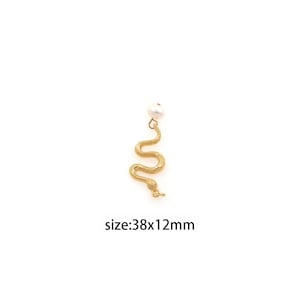 Könnte beinhalten: Goldener Schlangenanhänger mit einer weißen Perle oben. Der Anhänger ist 38 mm x 12 mm groß.