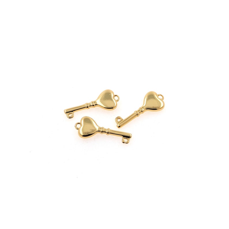Puede incluir: Tres dijes de llave en forma de coraz&oacute;n de color dorado. Las llaves tienen un dise&ntilde;o simple con un bucle en la parte superior para sujetarlas a un collar o pulsera.