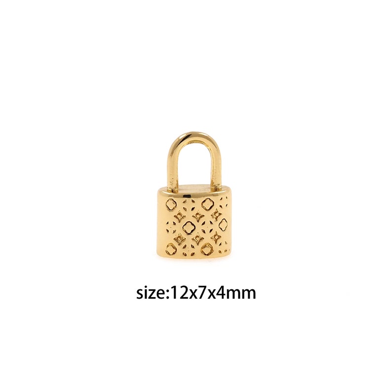 Puede incluir: Un dije de candado dorado con un patr&oacute;n geom&eacute;trico. El dije mide 12 mm x 7 mm x 4 mm.