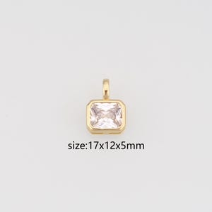 May include: A gold-toned pendant featuring a rectangular, clear faceted gemstone set in a bezel frame with a top bail. The pendant is labelled with the dimensions size: 17x12x5mm, indicating its physical measurements in millimetres for reference.