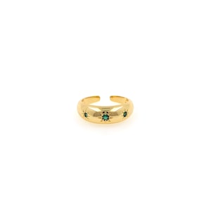 May include: Gold ring with three green star-shaped gemstones.