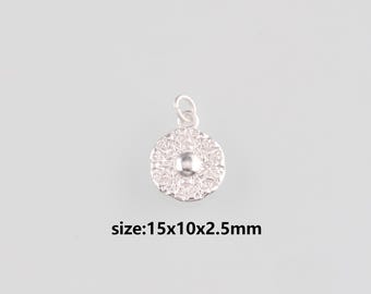 Puede incluir: Un pequeño colgante plateado con un diseño circular texturizado. El colgante tiene una cuenta central en relieve y un lazo para sujetarlo a una cadena. Mide 15x10x2,5mm. El texto en la imagen dice: size:15x10x2.5mm.