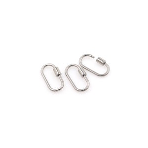May include: Three silver oval-shaped clasps with a cylindrical closure. The clasps are arranged in a row, with the top clasp slightly offset to the right.