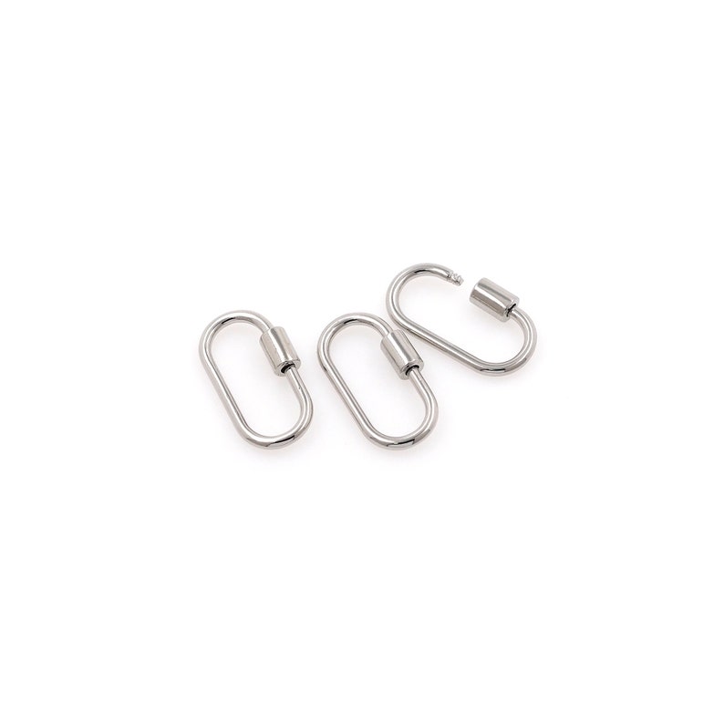 May include: Three silver oval-shaped clasps with a cylindrical closure. The clasps are arranged in a row, with the top clasp slightly offset to the right.