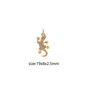 Op de afbeelding: Gouden hanger in de vorm van een hagedis, bezet met heldere, glinsterende strass steentjes. De hanger is 19 x 8 x 2,5 mm.