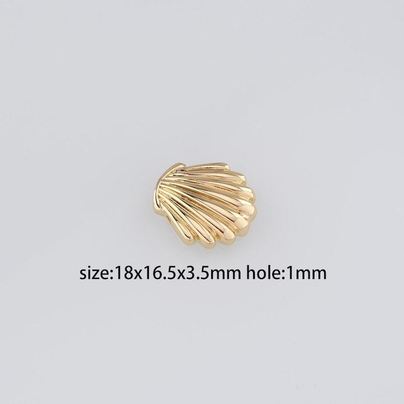 Pu&ograve; includere: Abbellimento in metallo a forma di conchiglia color oro con un foro di 1 mm. Dimensione: 18 x 16,5 x 3,5 mm.