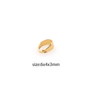 May include: Gold-toned metal jump ring with a smooth finish. The jump ring is 6mm long, 4mm wide, and 3mm thick. size:6x4x3mm