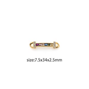 Op de afbeelding: Gouden connector met een rij van kleurrijke vierkante edelstenen. De connector meet 7,5 mm bij 34 mm bij 2,5 mm.