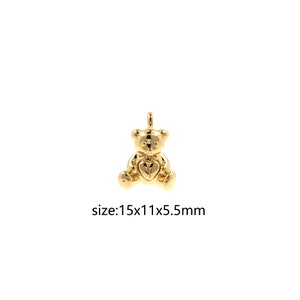 Op de afbeelding: Een gouden teddybeerbedel met een hart op zijn borst. De bedel is 15 mm lang, 11 mm breed en 5,5 mm dik.