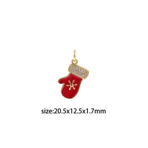 May include: Gold-tone charm in the shape of a red mitten with a snowflake design. The mitten is decorated with clear rhinestones. The charm measures 20.5 mm x 12.5 mm x 1.7 mm.