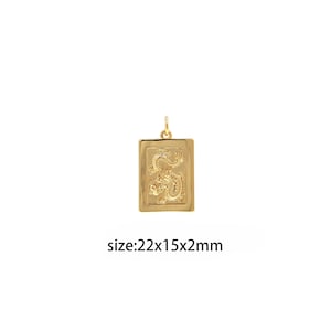Puede incluir: Colgante de oro con un diseño de dragón en un marco rectangular. El colgante mide 22x15x2mm.