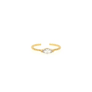 May include: A gold ring with a clear marquise-shaped gemstone set in the center. The band is beaded.
