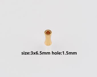 May include: A small, gold-colored bead with a cylindrical hourglass shape. The text on the image reads: size:3x6.5mm hole:1.5mm. This bead is likely used for jewelry making or other crafts.