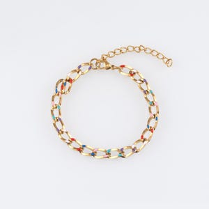May include: A gold chain bracelet with colorful enamel accents. The bracelet has a lobster clasp closure and an extender chain.