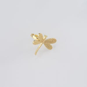 May include: A gold dragonfly ring with a textured finish.