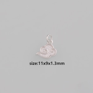 Puede incluir: Un charm de plata con forma de nube y superficie texturizada. El charm mide 11x9x1,3 mm. Tiene un lazo para sujetarlo a un collar o pulsera. El diseño de la nube es un símbolo popular.