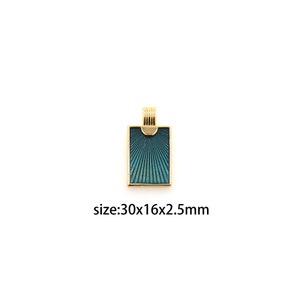 Puede incluir: Un colgante dorado con un diseño de esmalte azul y verde. El colgante es rectangular y tiene un patrón de rayos de sol. El colgante mide 30x16x2,5 mm.