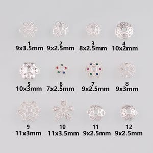 Puede incluir: Una colección de doce capuchones de cuentas plateados en varios diseños florales y geométricos. Los tamaños varían de 7x2,5 mm a 11x3,5 mm. Algunos capuchones presentan gemas de colores.