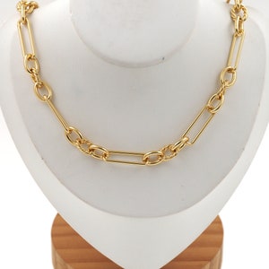 May include: A gold chain necklace with a combination of oval and rectangular links. The chain is displayed on a white mannequin bust.