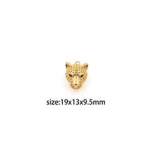 Può includere: Ciondolo in metallo dorato a forma di testa di leopardo. Il ciondolo è dettagliato con una superficie testurizzata e ha una dimensione di 19x13x9,5 mm.