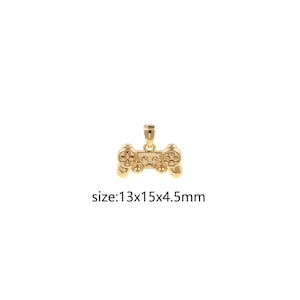 May include: A gold-colored pendant in the shape of a video game controller. The pendant has detailed buttons and a loop for a chain. The text "size: 13x15x4.5mm" is below the pendant.