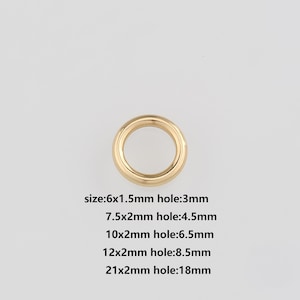 May include: A gold-colored metal ring with a circular shape. The image includes text indicating various sizes, including a 6x1.5mm ring with a 3mm hole, and a 21x2mm ring with an 18mm hole.