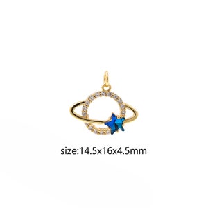 May include: Gold-toned pendant featuring a circle with a blue star in the centre, surrounded by a ring of clear rhinestones. The circle is attached to a smaller ring with a ring of clear rhinestones. The pendant measures 14.5 x 16 x 4.5 mm.