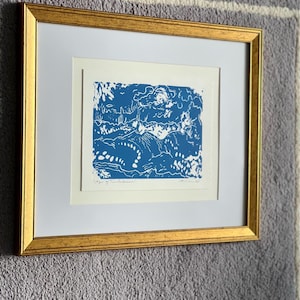 May include: Framed art print in a gold-coloured frame. The artwork displays a blue and white landscape design. The print is matted with a white border. The artwork is titled "Age of Turbulence".