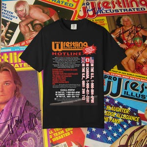 May include: Black t-shirt featuring the "Pro Wrestling Illustrated Hotline" logo in orange and white. The shirt includes text about wrestling news and phone numbers for calls from the U.S., Canada, and the U.K. The background features wrestling magazine covers.