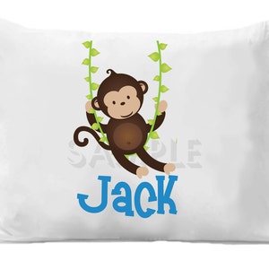 May include: White pillowcase with a brown monkey swinging on green vines. The monkey is smiling and has a blue name "Jack" printed below it.