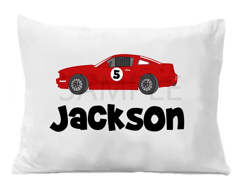 May include: White pillowcase with a red race car with the number 5 on the side and the name Jackson in black letters.