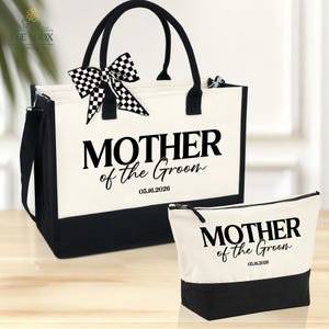 May include: A tote bag and cosmetic bag set with the text "MOTHER of the Groom" and the date 05.16.2026. The bags are white with black accents and black handles. A black and white checkered bow adorns the tote bag.