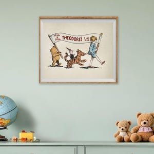 May include: A framed print featuring Winnie the Pooh characters. The illustration shows Pooh, Piglet, and Tigger carrying a banner that reads "THEODORE!" with the date and weight. The artwork is in a wooden frame and is displayed on a light green wall.