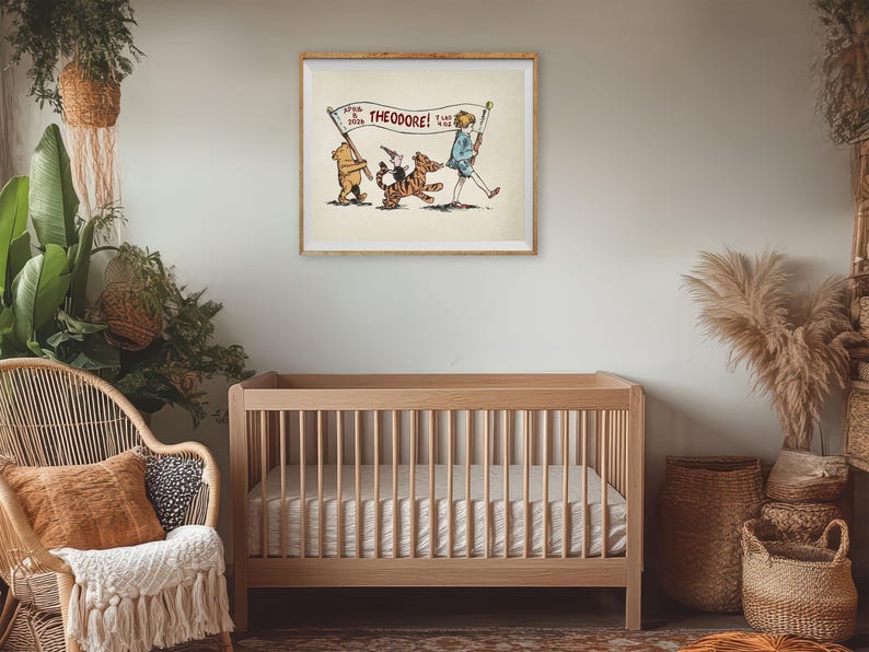 May include: A framed illustration featuring Winnie the Pooh, Tigger, and Christopher Robin. The characters are marching with a banner that reads "Theodore!" The artwork is displayed above a wooden cot in a nursery setting.