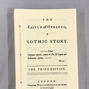 Könnte beinhalten: Ein Vintage-Buch mit dem Titel "The Castle of Otranto, A Gothic Story". Das Cover ist cremefarben mit schwarzem Text, einschließlich "The Third Edition" und den Verlagsinformationen. Das Buch ist mit Faden gebunden.