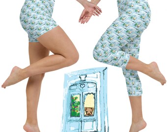 May include: Two pairs of blue and white patterned leggings and shorts with a cartoon illustration of a door with a Christmas tree and a dog peeking out.