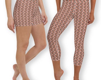 May include: High-waisted shorts and capri leggings with a repeating pattern of brown dachshunds wearing red hats on a light pink background. The shorts are above the knee, and the leggings are cropped at the calf.